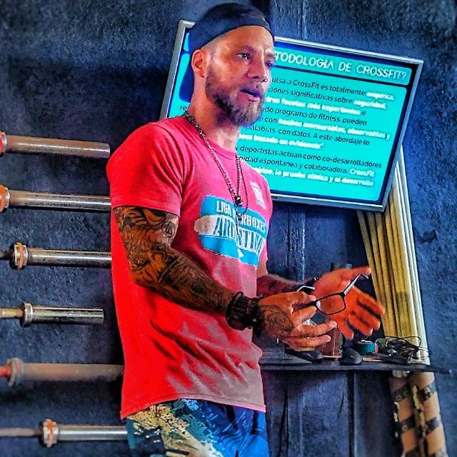 Johnny explicando la metodología de CrossFit junto a una pantalla